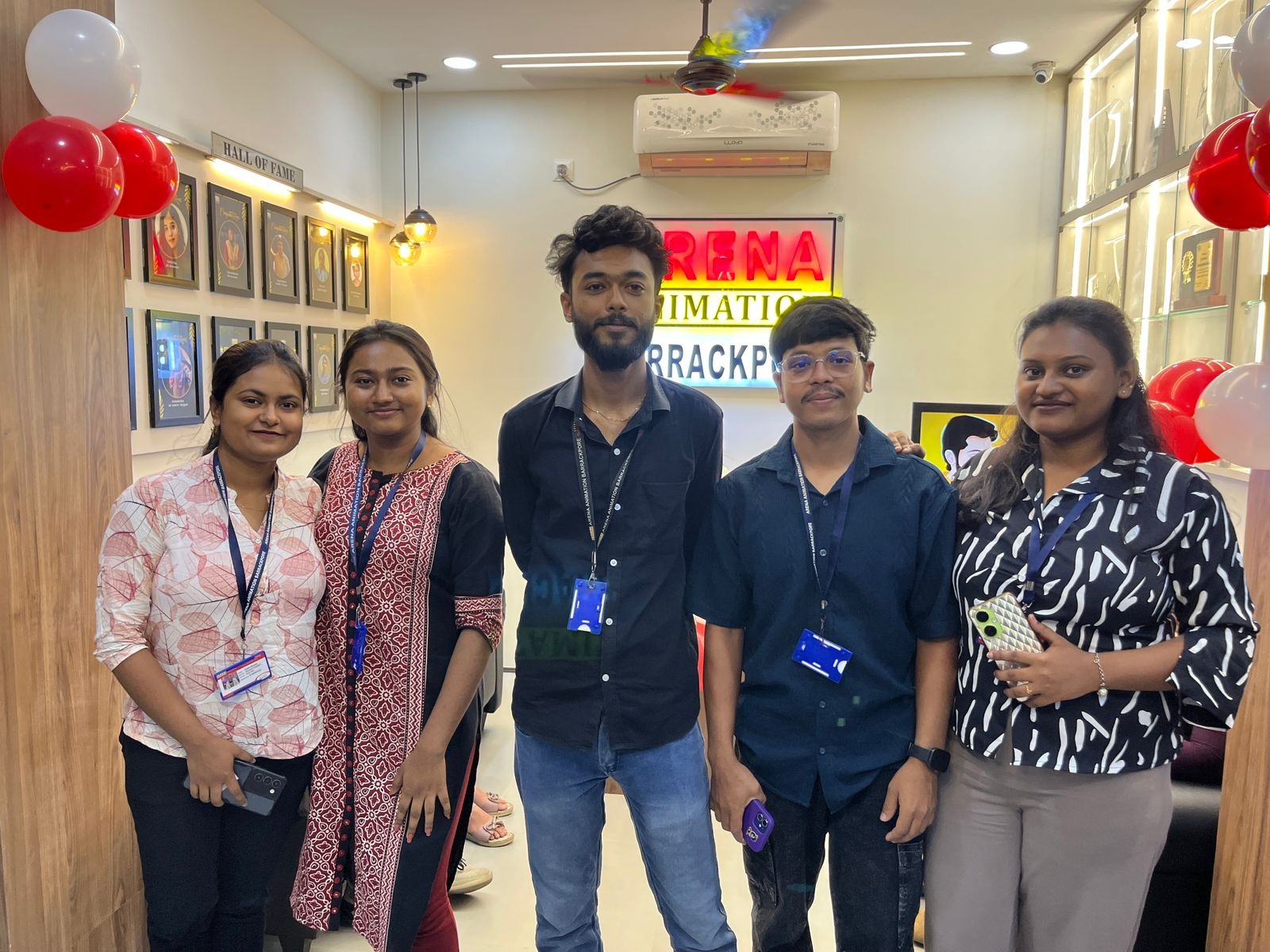 Small group of students at Arena sign